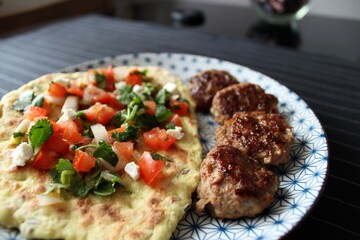 Greek grill meatball on pita with tomato and cucumbers