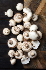 Raw white champignons on a wooden board