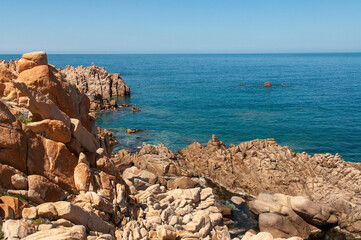 Fototapeta na wymiar Rock pink granitic formation at Costa Paradiso beach in Sardinia Italy with turquoise blue sea
