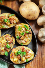 Baked potatoes in jacket stuffed with bacon, mushrooms and chees