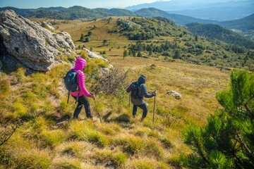 Lovely tourist couple hiking down the Slovenian rocky mountains under the blue sky