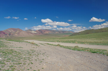 Mongolian Altai. Mountain pass. Dirt road. Scenic valley and multicolor mountains. Nature and travel. Mongolia, Bayan-Olgii Province