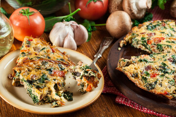 Portion of frittata made of eggs, mushrooms and spinach