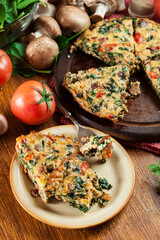Portion of frittata made of eggs, mushrooms and spinach
