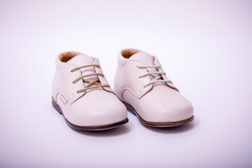 Small child white leather shoes isolated on white background.