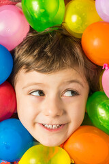 Fototapeta na wymiar Portrait of a boy with his face surrounded by water balloons.