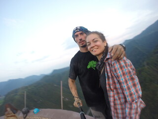 Taking an extreme selfie on top of a ruined tower, life risking extreme sports, happy couple enjoying the panorama 