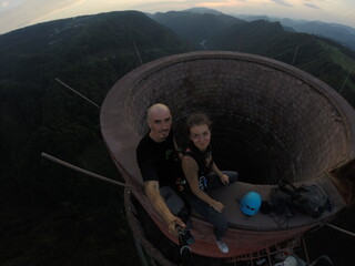 Taking an extreme selfie on top of a ruined tower, life risking extreme sports, happy couple enjoying the panorama 