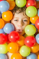 Fototapeta na wymiar Portrait of a boy with his face surrounded by colored balls.