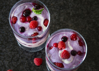 Joghurt, Pudding Dessert, Nachtisch im Glas mit Früchten, Beeren und einem Minzblatt