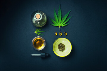 Medical CBD oil, tincture on black trendy background with cannabis leaves