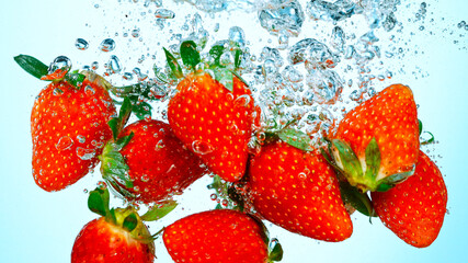 Freeze Motion Shot of Fresh Strawberries Falling Into Water Isolated on White Background.