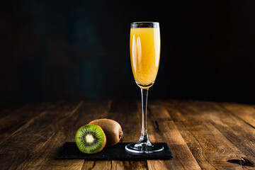 A sparkling cocktail with kiwi in a flute glass © jamurka