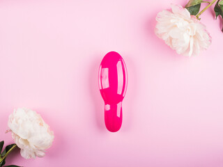 Torre Annunziata, Naples, Italy - June, 12, 2020: pink Tangle Teezer hair brush for girls in frame of white peonies on pink background. Flat lay