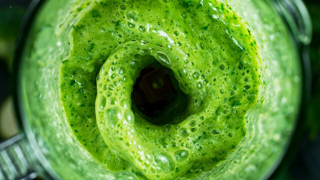 Green fresh smoothie blended in blender, top view. Healthy eating concept.