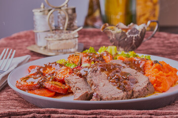 Beef roast dinner with gravy,shot close up with some condiments in the background.