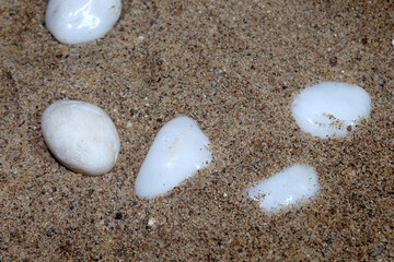 White pebble stones lie on a sand