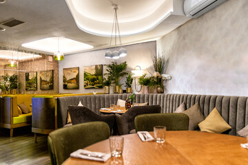Interior of cozy modern restaurant with soft sofas and armchairs