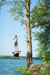 In the summer, on a bright sunny day, children ride a bungee on the lake.