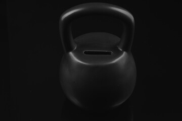 Kettle bell money box,shot on a black background and black surface.
