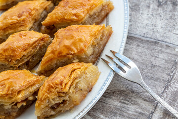 Turkish national delight baklava with walnuts and honey on a white wooden background. Traditional eastern dessert.