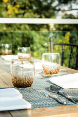 Outdoor table sitting including water glass, napkin and silver spoon fork