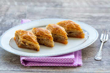 Turkish national delight baklava with walnuts and honey on a white wooden background. Traditional eastern dessert.