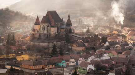 Evening In Biertan,Heart Of Transylvania,One Of Most Famous Four Ancient Fortification Churches Of Romania.Val-Themed Inns And Pastel-Coloured Houses With Dilapidated Tiled Roofs Surround The Fortress - 358628656