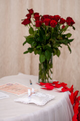 Wedding rings on a pillow for rings on a background of a bouquet of red roses