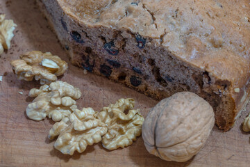 Homemade cake with walnuts and other exquisite ingredients, on the table. Detail of walnuts with and without shells.