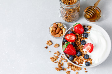 Homemade oatmeal granola bowl with greek yogurt, berries, honey and nut.