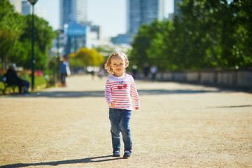 Fototapeta premium Cheerful toddler girl running on a street of Paris, France