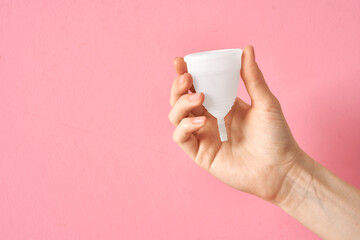 Menstrual cup eco friendly reusable and silicone in woman's hand isolated on a white background
