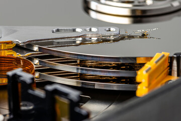 Macro photo of a magnetic needle on a hard disk, an open HDD with three plates.