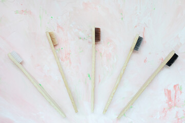 Natural wooden bamboo toothbrushes. Plastic free and zero waste concept. Top view, pink backgroundon