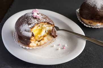Sponge cake filled with vanilla cream and covered with chocolate icing - Mohrenkopf