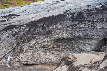 Woman feeling on the tongue of Myrdals Jokull Glacier near Skogar SW Iceland