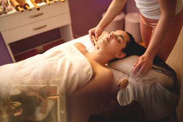Obraz na płótnie Canvas Young woman receiving massage in spa salon.