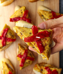 Spanish tortilla pintxo on a wooden board. Potato omelette on bread as a basque canape on sharing...