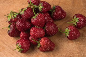 A bunch of strawberries on a wooden board