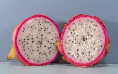 Pitaya fruit (Selenicereus setaceus) cut in half on blue background