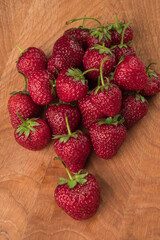 A bunch of strawberries on a wooden board