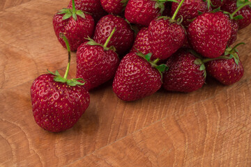 A bunch of strawberries on a wooden board