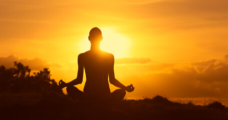 Fototapeta premium silhouette of a woman meditating in the sunset