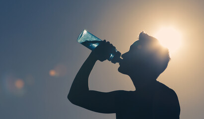 Young man drinking water.  - obrazy, fototapety, plakaty