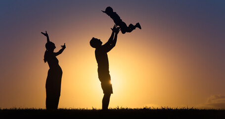 Fototapeta na wymiar Happy family outdoors lifestyle silhouette. Father throwing up son in the air with happy pregnant mother cheering then on. 