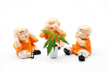 Blind stumm taub, Buddhisten sitzen um einen Fingerhut mit einer Cannabis-Pflanze. Nichts hören,...