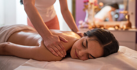 Fototapeta na wymiar Young woman receiving massage in spa salon.