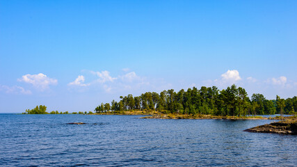 Fototapeta premium It's Landscape of the trees on the coast of the blue river