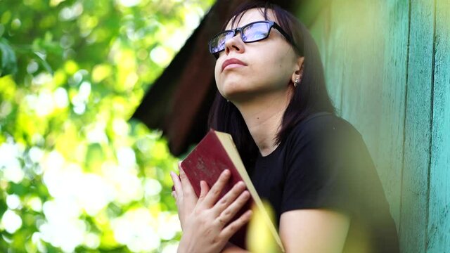 young adult, woman, hold, hugging, book, garden, female, casual, style, enjoying, leisure time, thoughtful, brunette, short hair, reflective, look, looking away, contemplating, lady, resting, sit, rel